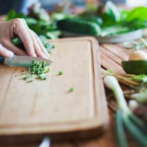 Femme coupe des herbes en cuisine